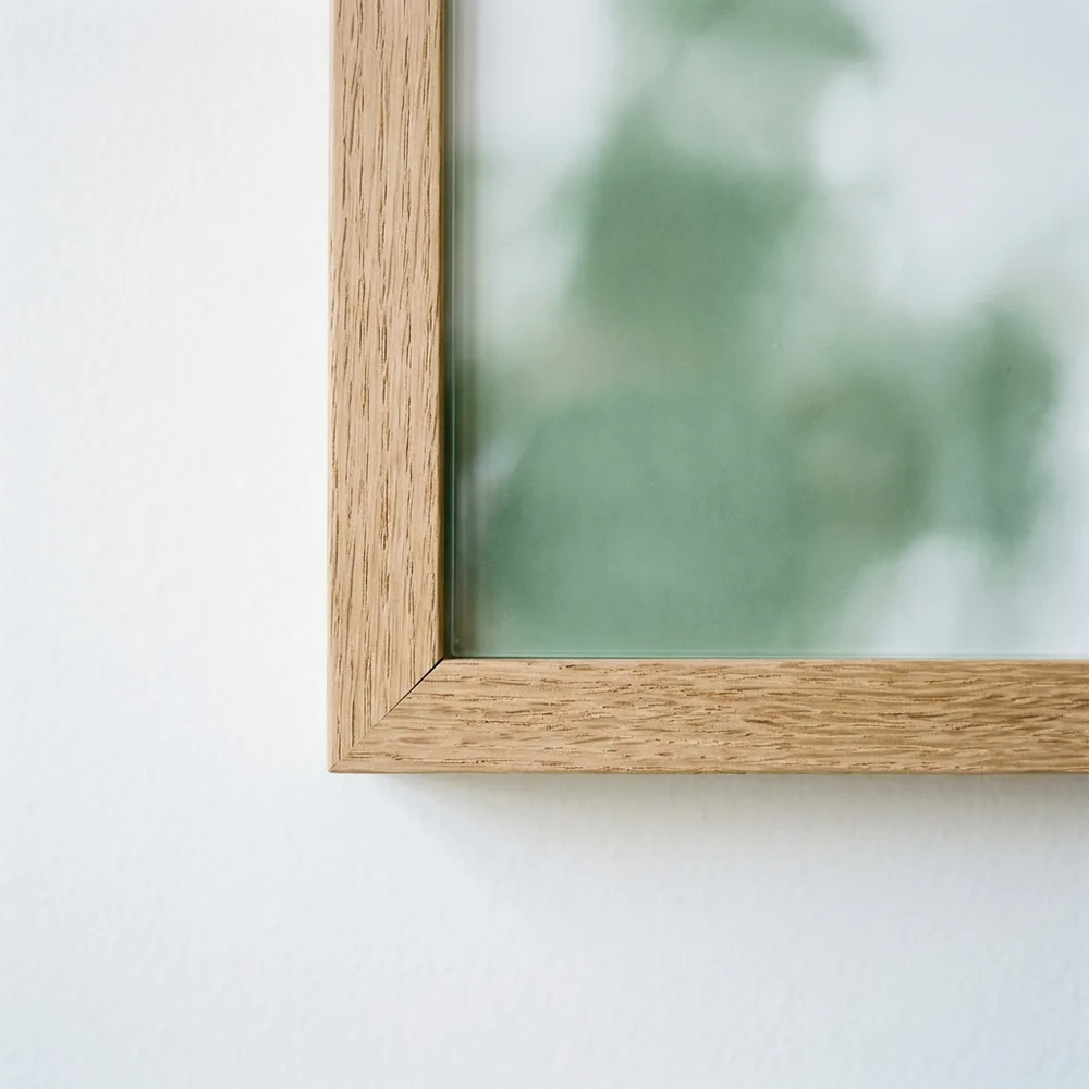 The mitred corner of a natural wood frame with the sheet edge to edge